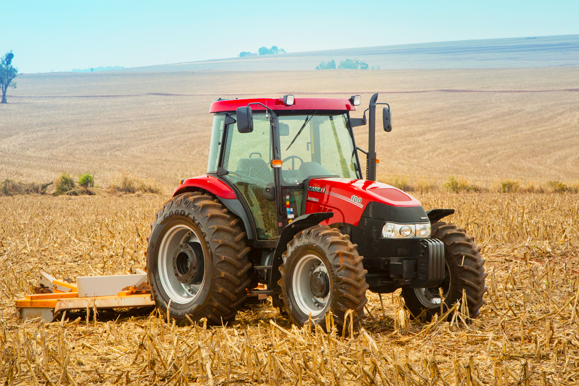 Máquina agrícola vermelha em área rural