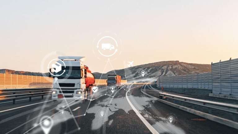Caminhões em rodovia ao entardecer com ícones de rastreamento e pontos de localização sobrepostos, representando a gestão de ativos por telemetria